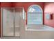 Relaxing bathroom showcasing a shower, soaking tub, and arched window at 9634 Coastal Pointe Dr, Villa Rica, GA 30180