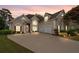 Charming two-story home with a well-manicured lawn, three-car garage, and inviting curb appeal during sunset at 9634 Coastal Pointe Dr, Villa Rica, GA 30180