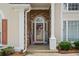 Close-up of front door with stone accents and patriotic decorations, creating a welcoming entrance at 9634 Coastal Pointe Dr, Villa Rica, GA 30180