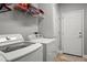 Functional laundry room with modern washer and dryer, with storage on shelves above at 9634 Coastal Pointe Dr, Villa Rica, GA 30180