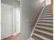 Hallway staircase boasts wood treads, painted risers, and modern gray wall paint at 9634 Coastal Pointe Dr, Villa Rica, GA 30180