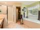 Well-lit bathroom featuring a soaking tub, a glass enclosed shower, and tiled floors at 180 Moseley Crossing Dr, Stockbridge, GA 30281
