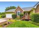 Inviting front entrance with a well-maintained lawn, colorful flower bed, and a charming covered porch at 180 Moseley Crossing Dr, Stockbridge, GA 30281