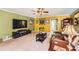 Bright living room featuring plush carpeting, a large television, and comfortable seating at 180 Moseley Crossing Dr, Stockbridge, GA 30281