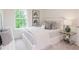 Cozy bedroom with a bed decorated in whites and grays, and a view of greenery outside a bright window at 2686 Ne Almand Ne Ln, Conyers, GA 30013