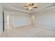 Spacious bedroom with neutral walls, a tray ceiling, and a ceiling fan at 100 Homesite Valleyview Ct, Mcdonough, GA 30252