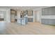 Open-concept kitchen with gray cabinets, a center island, and light wood-look flooring at 100 Homesite Valleyview Ct, Mcdonough, GA 30252