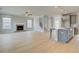 Open-concept living space featuring a fireplace, light wood-look flooring, and kitchen island at 100 Homesite Valleyview Ct, Mcdonough, GA 30252