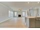 Spacious living area featuring a fireplace, light wood-look flooring, and kitchen in the background at 100 Homesite Valleyview Ct, Mcdonough, GA 30252