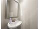 A well-lit half bath with a pedestal sink, decorative mirror, and neutral tones provides a convenient amenity at 2170 Trelipe Dr, Lawrenceville, GA 30044