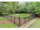 Fenced dog park with a walking trail, fire hydrant, and benches surrounded by trees at 3635 E Paces Ne Cir # 1405, Atlanta, GA 30326
