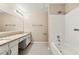 Bathroom featuring dual sinks, a tub, and white tile, ideal for a relaxing experience at 10545 Virginia Pine Ln, Alpharetta, GA 30022