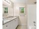 Bathroom featuring dual sinks, a tub, and neutral tile, offering a clean and inviting space at 10545 Virginia Pine Ln, Alpharetta, GA 30022