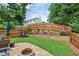 Picturesque backyard with lush lawn, fire pit, and a charming retaining wall with landscaping at 142 Holly Mill Village Dr, Canton, GA 30114