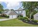 Charming two-story home with a stone accent facade and a well-manicured lawn at 142 Holly Mill Village Dr, Canton, GA 30114