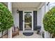 Close up of the front door, showing the storm door, sidelights, and front porch decor at 142 Holly Mill Village Dr, Canton, GA 30114