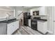 Kitchen featuring stainless steel appliances, ample counter space, and adjacent stairs at 142 Holly Mill Village Dr, Canton, GA 30114