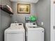 Functional laundry room with modern washer and dryer, plus shelving for storage at 142 Holly Mill Village Dr, Canton, GA 30114