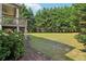 Lush backyard with a wooden deck, covered porch, pink hydrangea bushes, and mature trees at 2452 Stone Manor Ne Dr, Buford, GA 30519