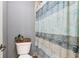 View of the toilet and shower with a blue patterned shower curtain at 2452 Stone Manor Ne Dr, Buford, GA 30519