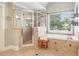Bright bathroom with tile flooring, a shower with glass door, and a large soaking tub at 2452 Stone Manor Ne Dr, Buford, GA 30519