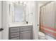 Compact bathroom featuring a grey vanity, stylish mirror, and shower-tub combo at 2452 Stone Manor Ne Dr, Buford, GA 30519