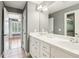 Bathroom featuring double vanity with white cabinets and view to bedroom with ceiling fan and hard wood floors at 2452 Stone Manor Ne Dr, Buford, GA 30519
