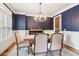 Dining room with dark blue walls, hardwood floor, and a piano at 2452 Stone Manor Ne Dr, Buford, GA 30519
