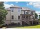 Two-story home with a wooden deck, a covered porch, a lush lawn, and mature trees at 2452 Stone Manor Ne Dr, Buford, GA 30519