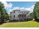 Two-story home with a wooden deck, a covered porch, a lush lawn, and mature trees at 2452 Stone Manor Ne Dr, Buford, GA 30519