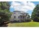 Two-story home featuring a wooden deck, a covered porch, a lush lawn, and mature trees at 2452 Stone Manor Ne Dr, Buford, GA 30519