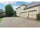 Spacious three-car garage with large concrete driveway, lush lawn, and mature shade trees in the background at 2452 Stone Manor Ne Dr, Buford, GA 30519