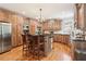 Gourmet kitchen boasts custom cabinets, hardwood floors, an island with seating, and stainless appliances at 2452 Stone Manor Ne Dr, Buford, GA 30519