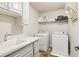 Well-lit laundry room with sink, countertop, and washer and dryer at 2452 Stone Manor Ne Dr, Buford, GA 30519