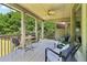 Inviting covered porch with a ceiling fan, comfortable seating, and relaxing outdoor TV area at 2452 Stone Manor Ne Dr, Buford, GA 30519