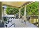 Covered porch boasts ample seating, a grill, and views of the backyard's lush landscaping and shade trees at 2452 Stone Manor Ne Dr, Buford, GA 30519