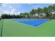 Well-maintained tennis courts with green and blue surfaces, surrounded by lush trees at 2452 Stone Manor Ne Dr, Buford, GA 30519