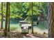 Wooded backyard with dock and boat nestled among lush green trees for a serene view at 6077 Lake Lanier Heights Rd, Buford, GA 30518