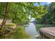 Waterfront view with private dock, lush greenery, boat, and tranquil water, creating an ideal setting for relaxation and enjoyment at 6077 Lake Lanier Heights Rd, Buford, GA 30518