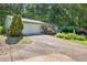 Well-maintained home with a two-car garage, American flag, and mature trees in a serene setting at 6077 Lake Lanier Heights Rd, Buford, GA 30518