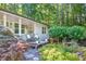 Quaint front porch with a cozy seating area, surrounded by lush landscaping and a serene garden at 6077 Lake Lanier Heights Rd, Buford, GA 30518