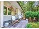 Welcoming front porch with comfortable seating and hanging flower baskets, enhancing the home's curb appeal at 6077 Lake Lanier Heights Rd, Buford, GA 30518
