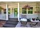 Charming front porch featuring hanging flower baskets and quaint decor, adding to the home's appeal at 6077 Lake Lanier Heights Rd, Buford, GA 30518