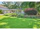 Charming home with lush green lawn, manicured landscaping, and flowering bushes enhances curb appeal at 6077 Lake Lanier Heights Rd, Buford, GA 30518