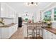 Bright kitchen with white cabinets, a breakfast bar, stainless steel appliances, and wood flooring at 6077 Lake Lanier Heights Rd, Buford, GA 30518