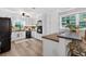 Charming kitchen featuring white cabinets, stainless appliances, wood floors, and a view to the entry hall at 6077 Lake Lanier Heights Rd, Buford, GA 30518