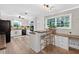 Well-lit kitchen featuring white cabinets, a breakfast bar, and modern appliances, perfect for cooking at 6077 Lake Lanier Heights Rd, Buford, GA 30518