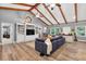 Spacious living room features a vaulted ceiling, wood floors, built-in shelves and a comfortable oversized sofa at 6077 Lake Lanier Heights Rd, Buford, GA 30518