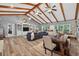Open-concept living room featuring vaulted ceilings, wood beams, and an adjacent dining area for seamless entertaining at 6077 Lake Lanier Heights Rd, Buford, GA 30518