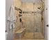 Modern tiled shower with glass door, built-in bench, and recessed shelves for toiletries at 6077 Lake Lanier Heights Rd, Buford, GA 30518